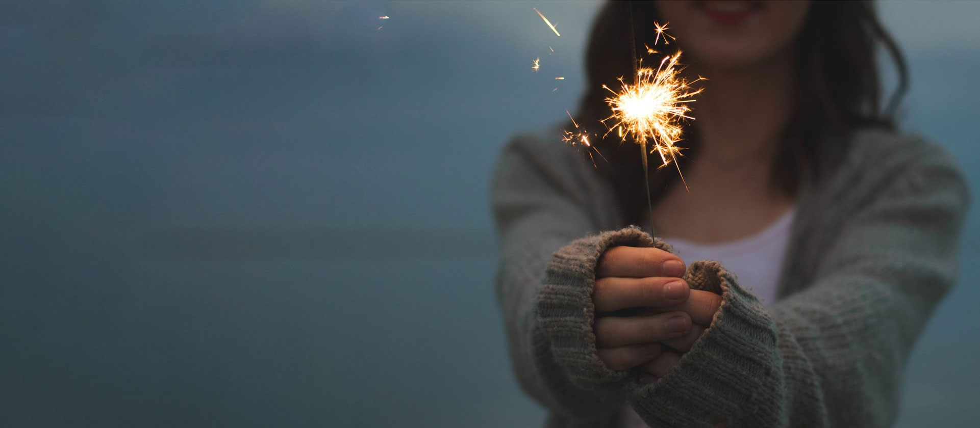 a woman holding a sparkler in her hands.